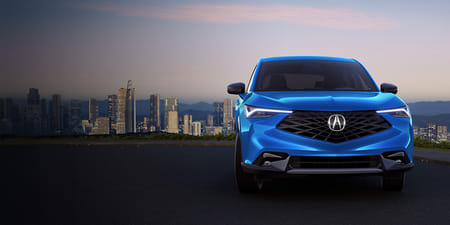 A blue 2026 ADX overlooking the city at sunset.