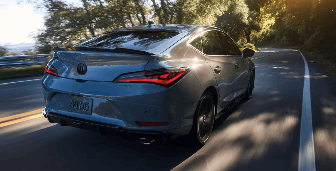 The 2026 Acura Integra car in Urban Gray Pearl driving on the road.