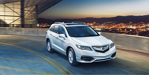 the Acura car is driving on the highway with a view of the city