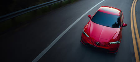 An overhead view of a red 2026 Integra making a turn on the road.