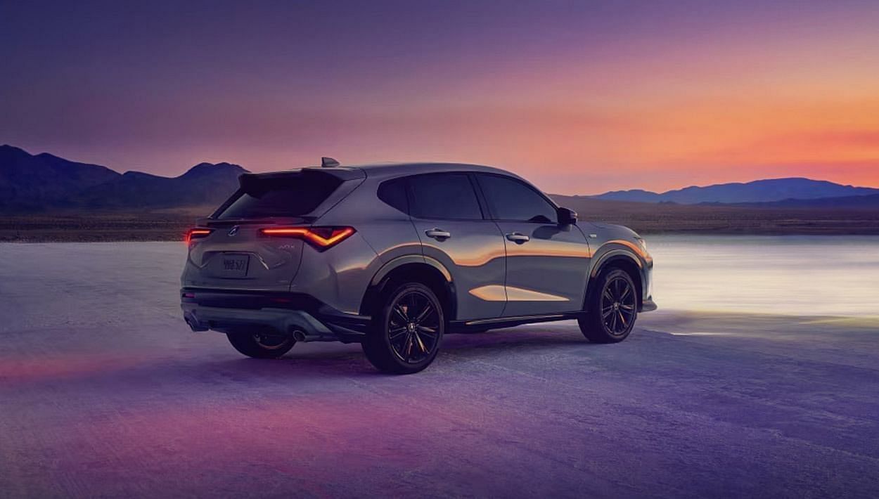 A 2025 Acura ADX parked in a desert landscape, showcasing its sleek design against a backdrop of sandy dunes.