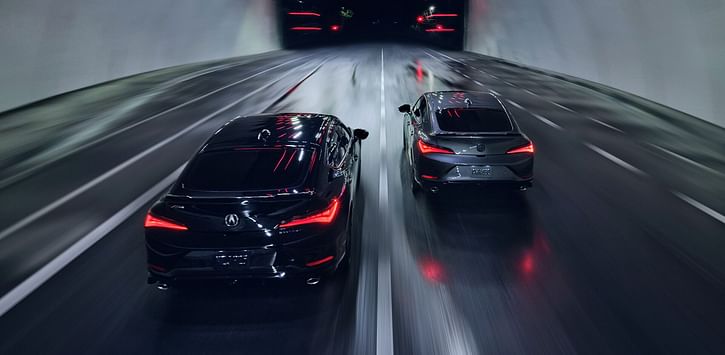 Two Acura models driving through a wet tunnel