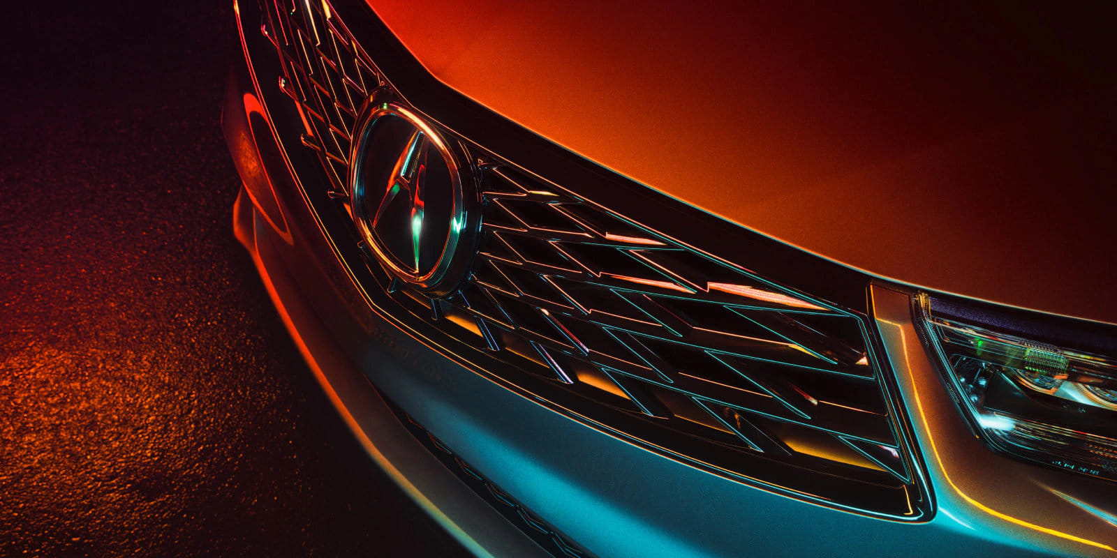 Close-up of the 2026 Acura RDX featuring the frameless Diamond Pentagon grille and blacked-out trim elements.