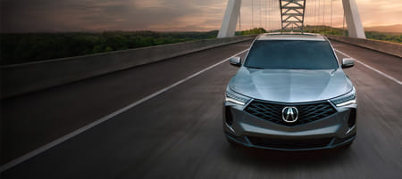 A front view of a gray 2026 RDX driving on the bridge.