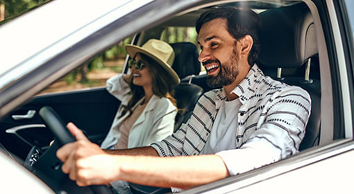 Man driving car, woman on passenger seat