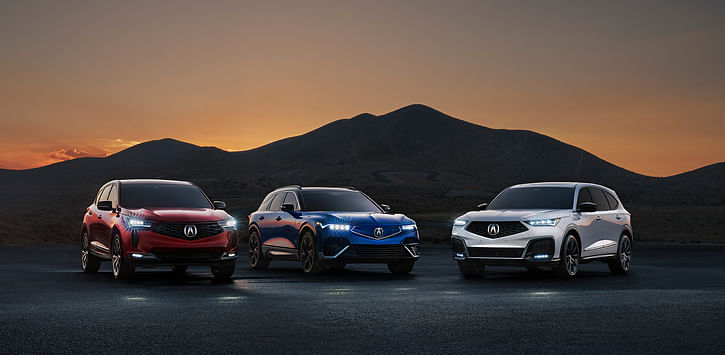 A blue ZDX, white mdx and red RDX parked in the mountains at night.