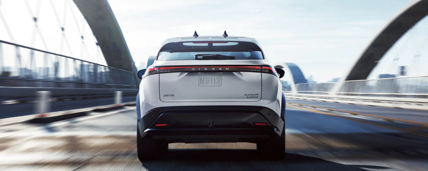 Rear view of the 2025 Nissan ARIYA featuring its wraparound LED taillight design that spans across the liftgate.