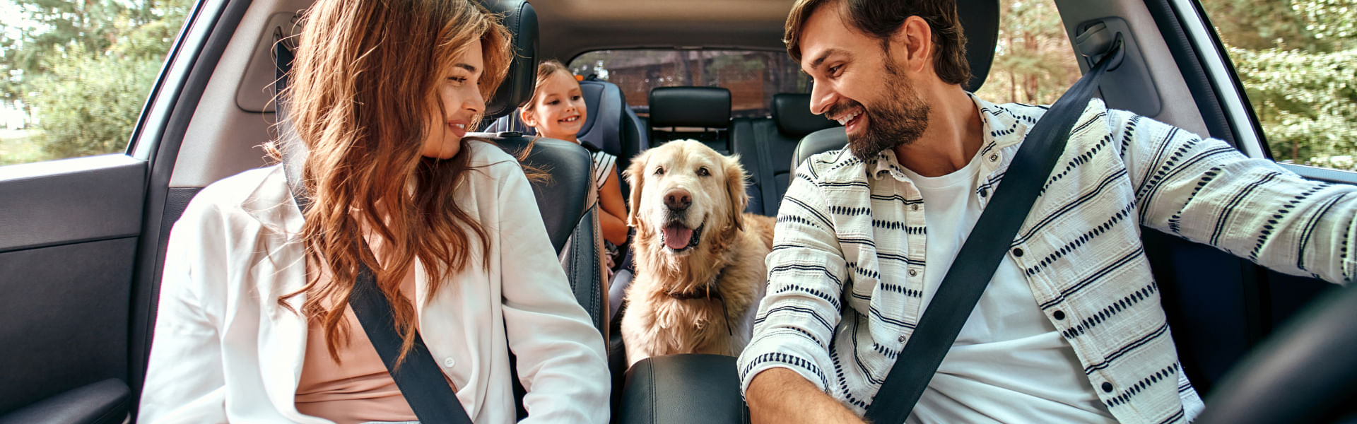 Family within car with dog