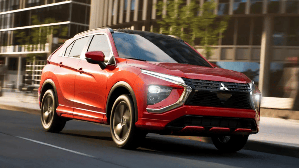 Red 2025 Mitsubishi Eclipse Cross driving through downtown Tampa, FL, capturing its aggressive styling and LED daytime running lights on city streets.