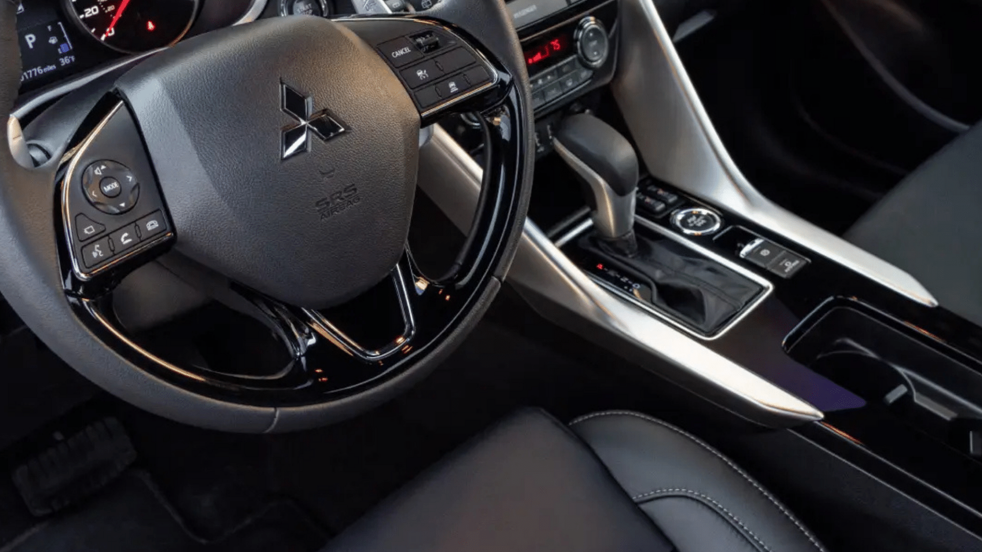 Interior detail of the 2025 Mitsubishi Eclipse Cross center console, featuring the gear shifter, drive mode selector, and multifunction steering wheel—highlighting modern design and driver-focused layout.