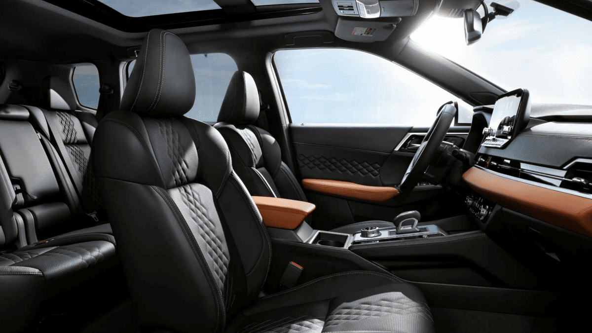 Interior of the 2025 Mitsubishi Outlander PHEV near Riverview, FL, showcasing diamond-stitched leather seats, contrasting orange accents, and panoramic sunroof, highlighting the SUV’s upscale plug-in hybrid interior design.