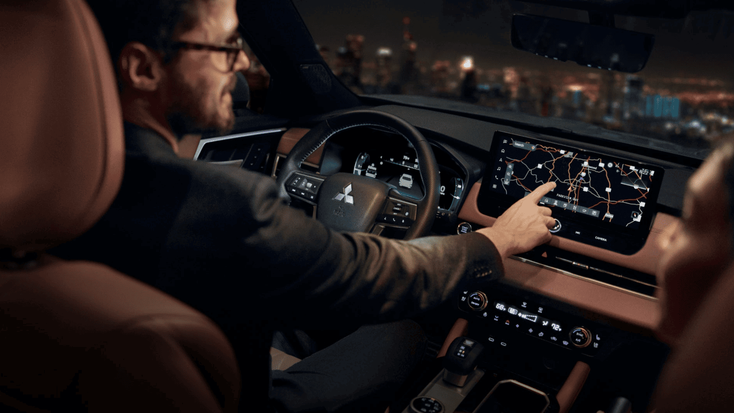 Man using the navigation system in the 2025 Mitsubishi Outlander near Valrico, FL, highlighting its modern touchscreen display.