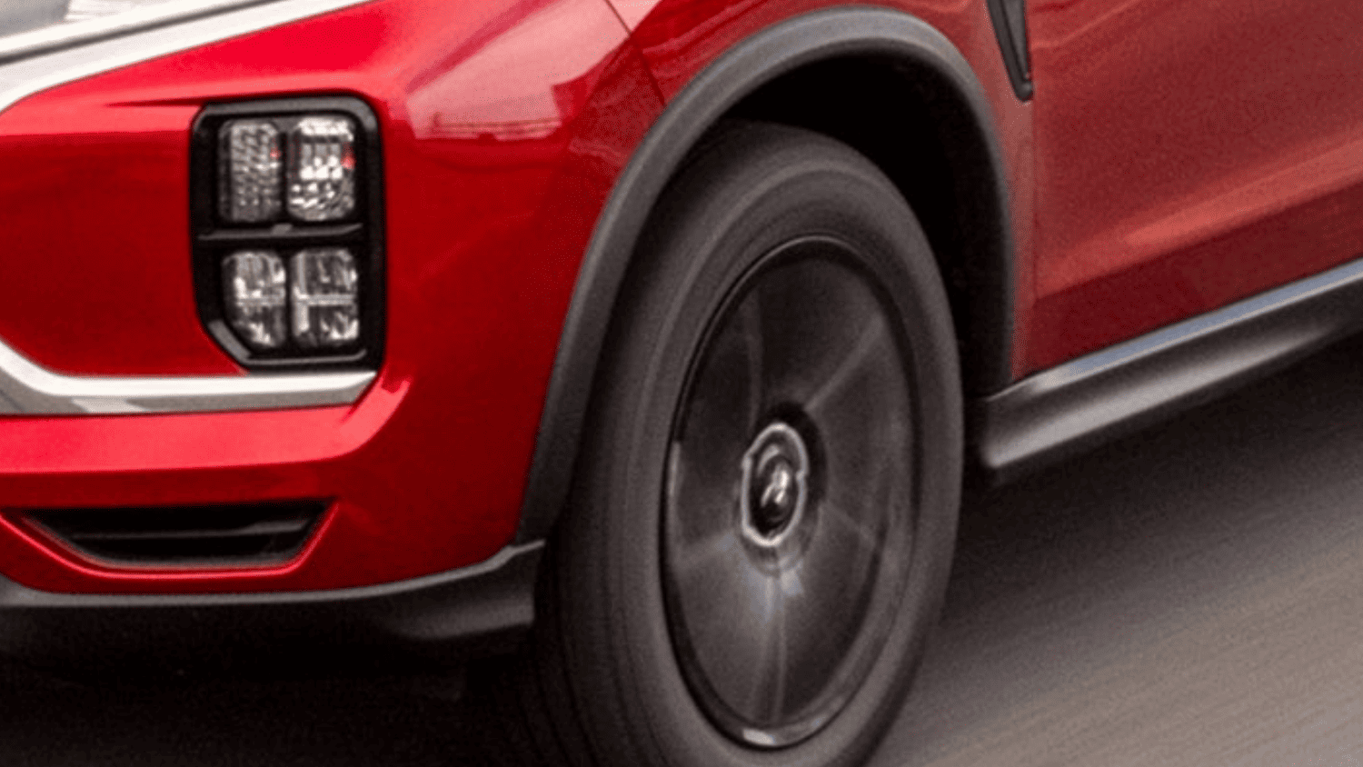 Close-up of the black alloy wheels and distinctive LED lighting on the 2025 Mitsubishi Outlander Sport, captured in motion near Lakeland, Florida.