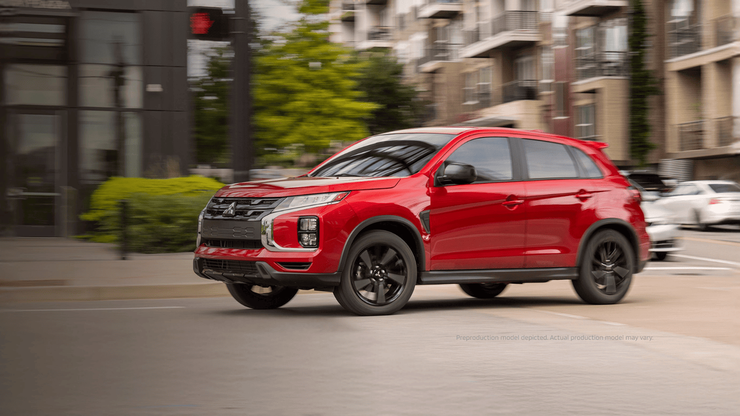 Front three-quarter view of a red 2025 Mitsubishi Outlander Sport near Valrico, FL, driving through the city.
