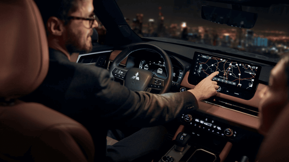 Driver’s hands interacting with the navigation screen of the 2025 Mitsubishi Outlander near Riverview, FL, emphasizing its user-friendly infotainment system and real-time directions.