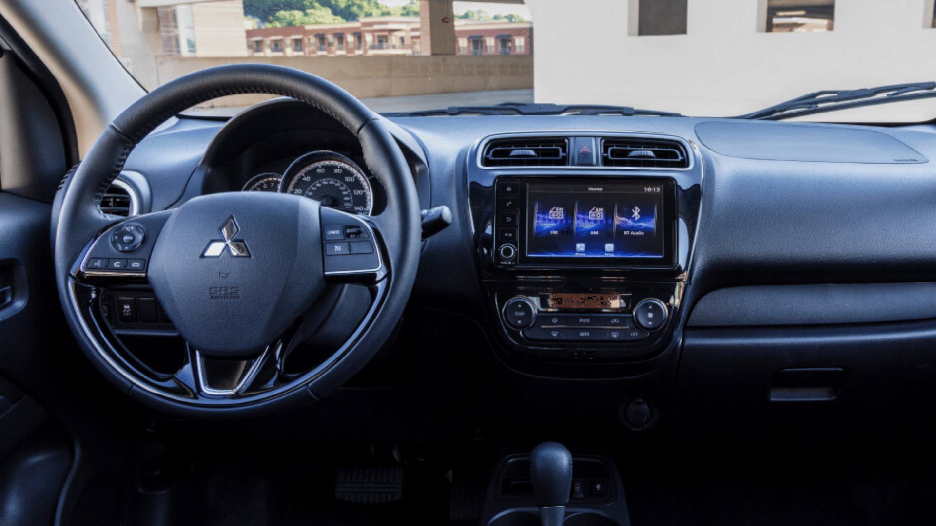 Interior dashboard of the 2024 Mitsubishi Mirage G4 with steering wheel, infotainment screen, and climate controls, captured near Tampa, FL for a tech-focused view.