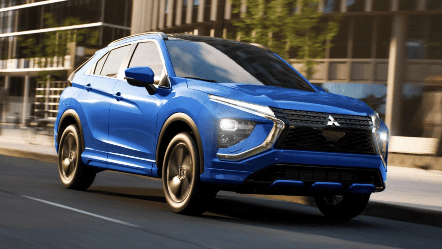 Rear view of the 2025 Mitsubishi Eclipse Cross in blue parked near downtown Lakeland, FL, showcasing its sporty design and black alloy wheels.