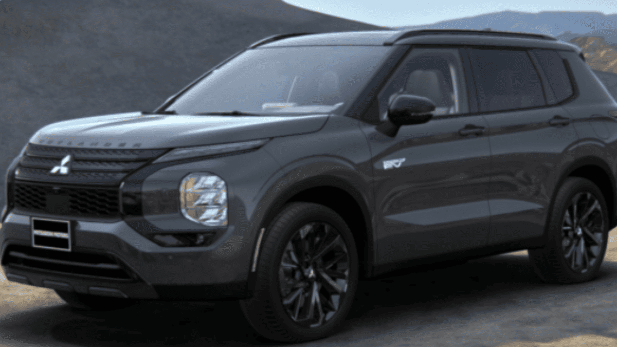 Dark gray 2025 Mitsubishi Outlander PHEV in Tampa, FL, parked in front of a modern home, highlighting its upscale trim design.