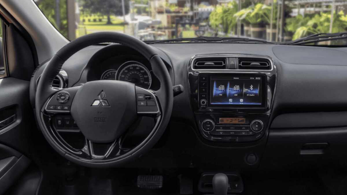 Interior view of the 2024 Mitsubishi Mirage dashboard and steering wheel near Tampa, FL, showing user-friendly infotainment and climate control layout.