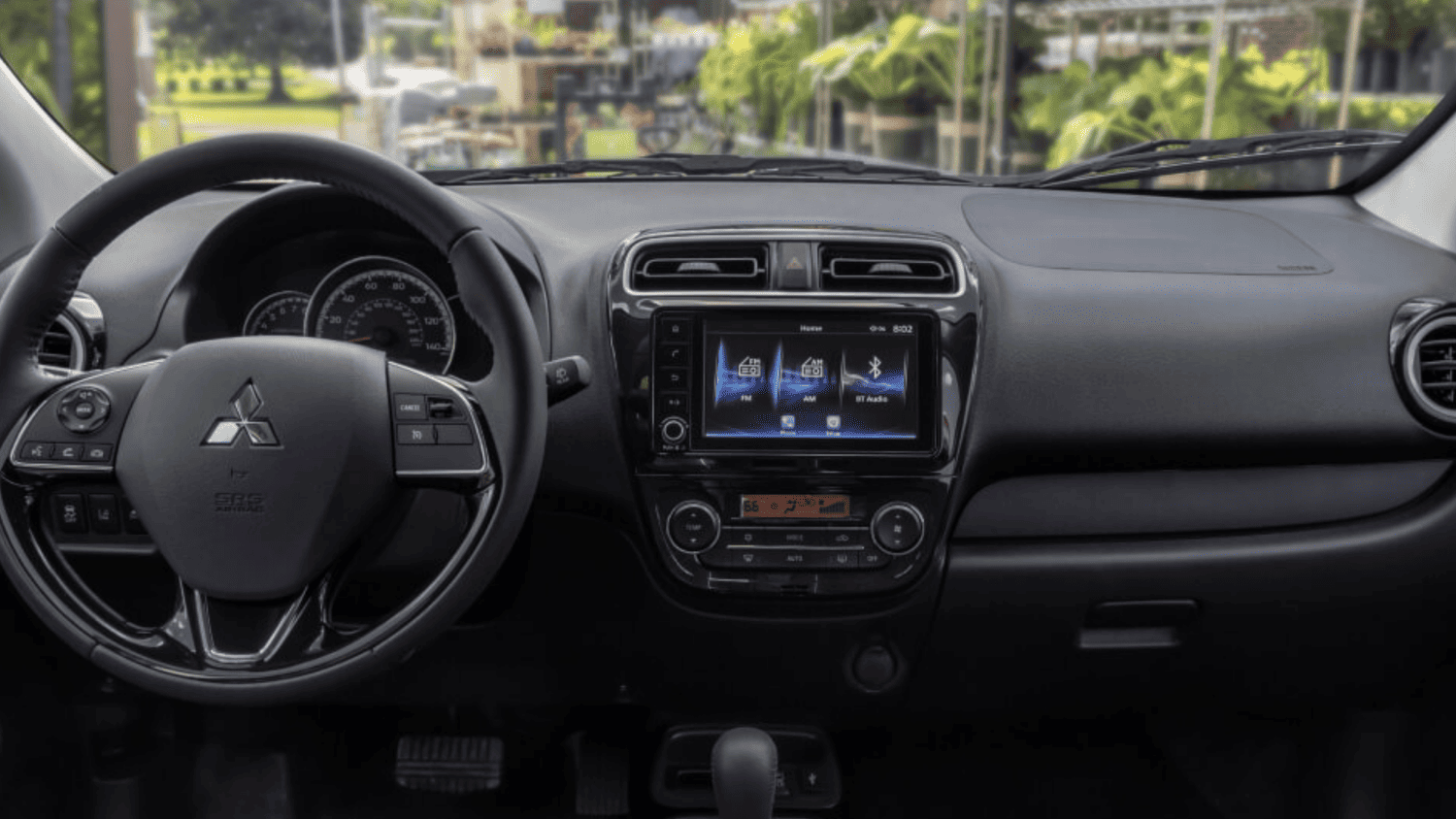 Interior cabin of the 2024 Mitsubishi Mirage near Valrico, FL, showcasing steering wheel controls and infotainment system.