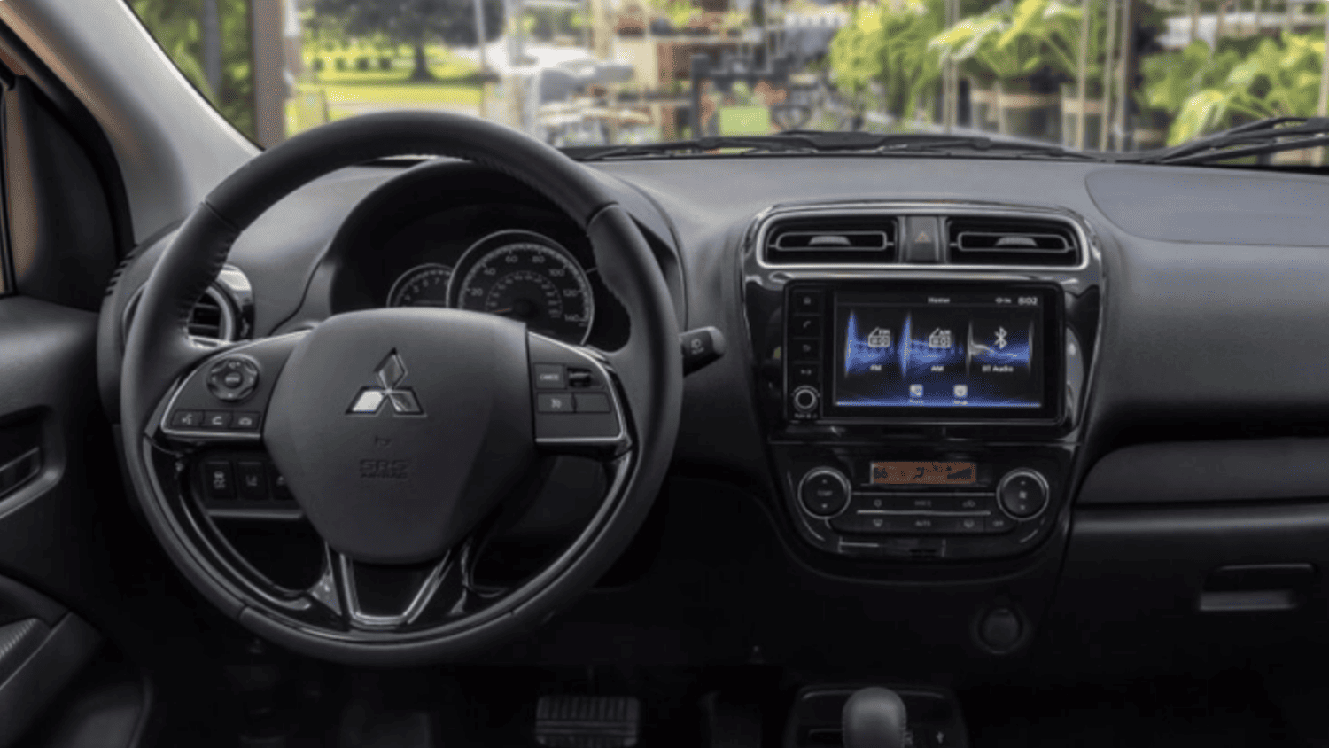 Interior view of the 2024 Mitsubishi Mirage showing steering wheel controls and a touchscreen infotainment system for Lakeland, FL drivers.