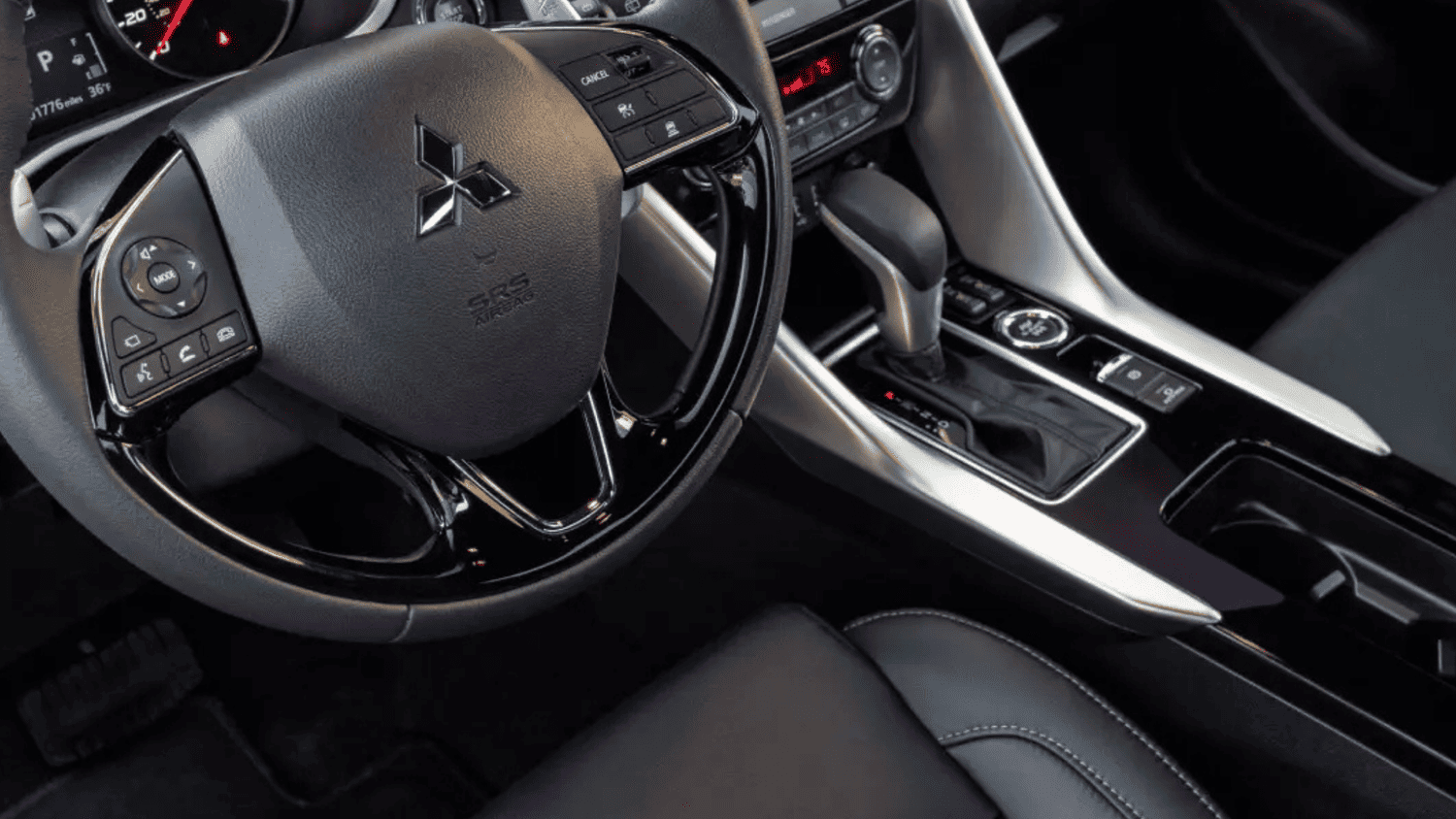 Close-up of the 2025 Mitsubishi Eclipse Cross interior near Valrico, FL, showing the gear shift and steering wheel design.
