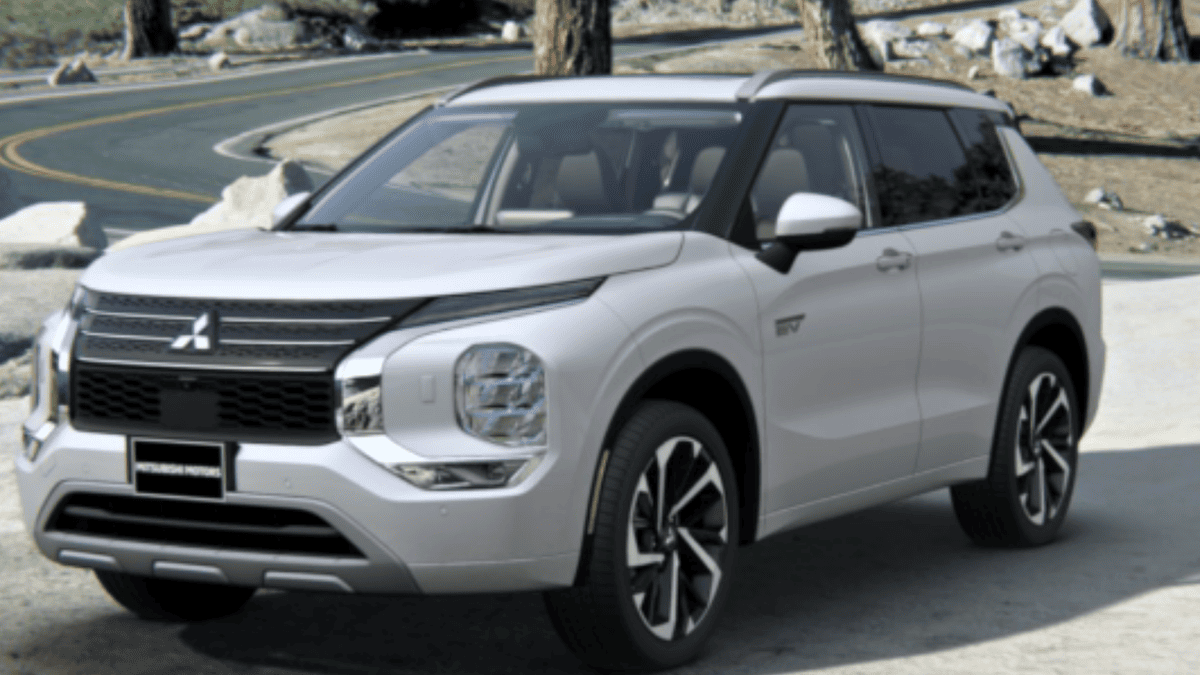 White 2025 Mitsubishi Outlander PHEV parked near Tampa, FL, showcasing its bold front grille and modern LED headlights.