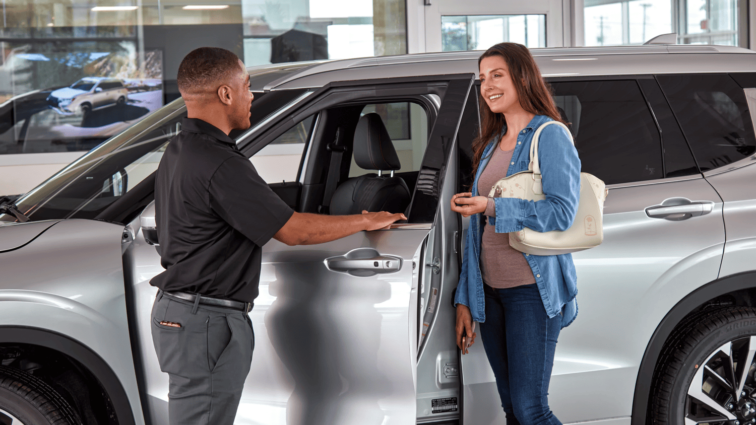  Certified Mitsubishi technician performing oil service under a raised vehicle near Lakeland, FL.