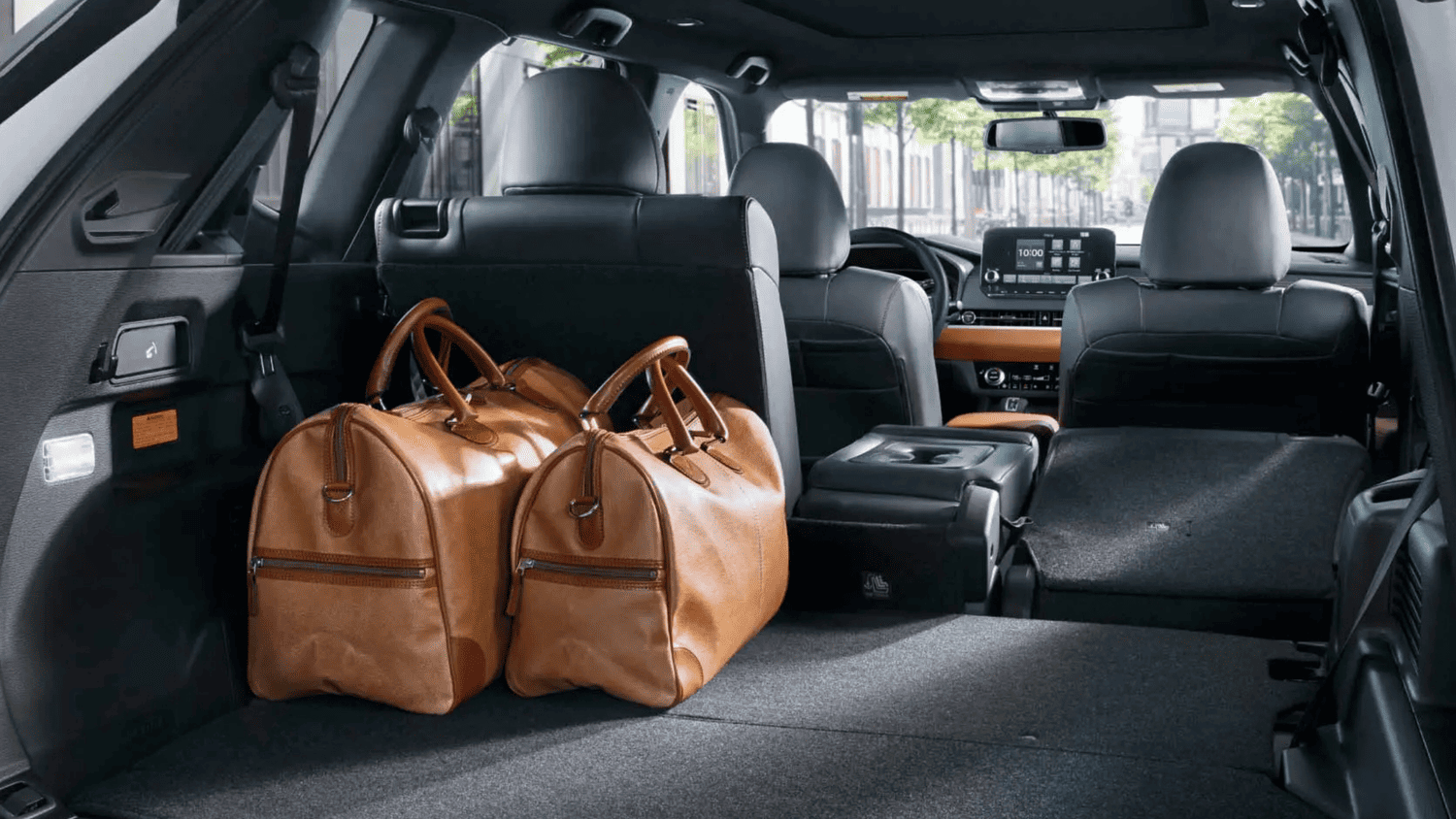 Spacious cargo area of the 2025 Mitsubishi Outlander shown with duffel bags packed for a Lakeland, FL weekend getaway.