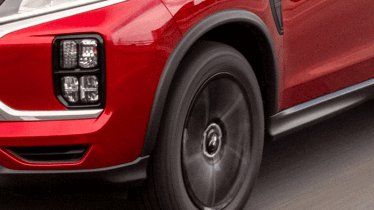 : Close-up of front LED headlights and sporty black alloy wheels on the 2025 Mitsubishi Outlander Sport near Tampa, FL.