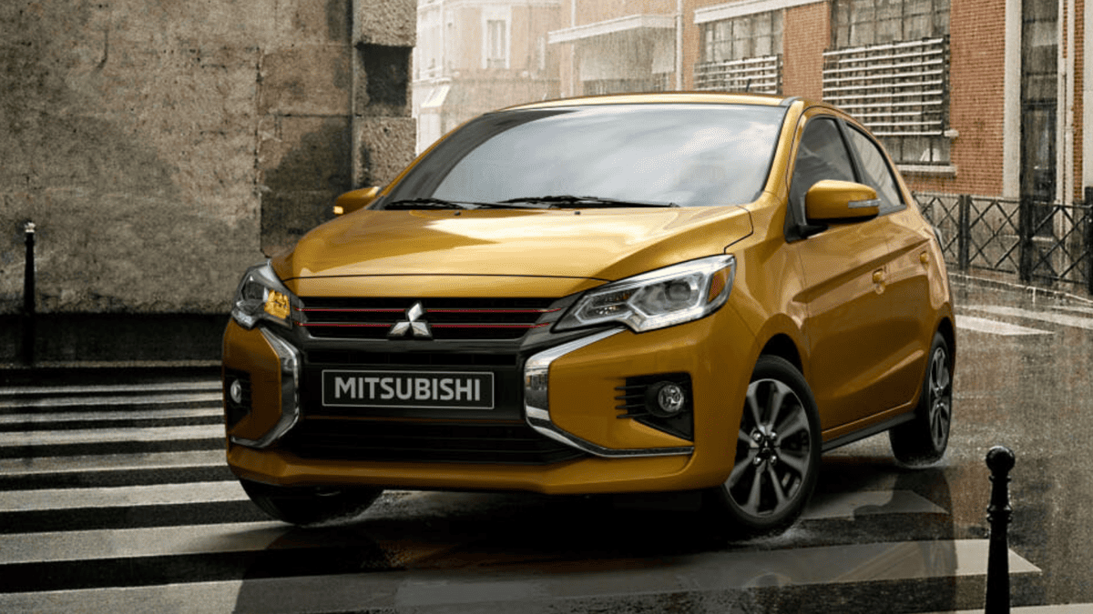 Bold yellow 2024 Mitsubishi Mirage parked on a rainy day in Tampa, FL, emphasizing its compact hatchback form and standout city-ready design.