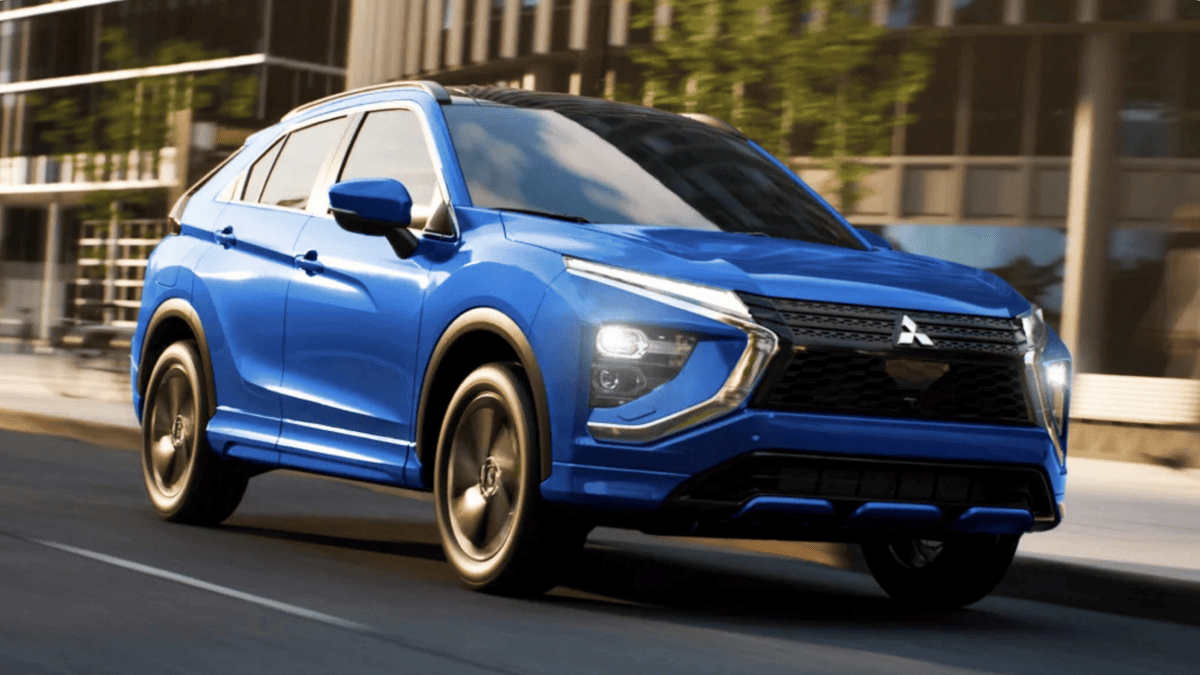 Blue 2025 Mitsubishi Eclipse Cross driving through downtown Tampa, FL, with dynamic front-end styling and LED headlights in motion.