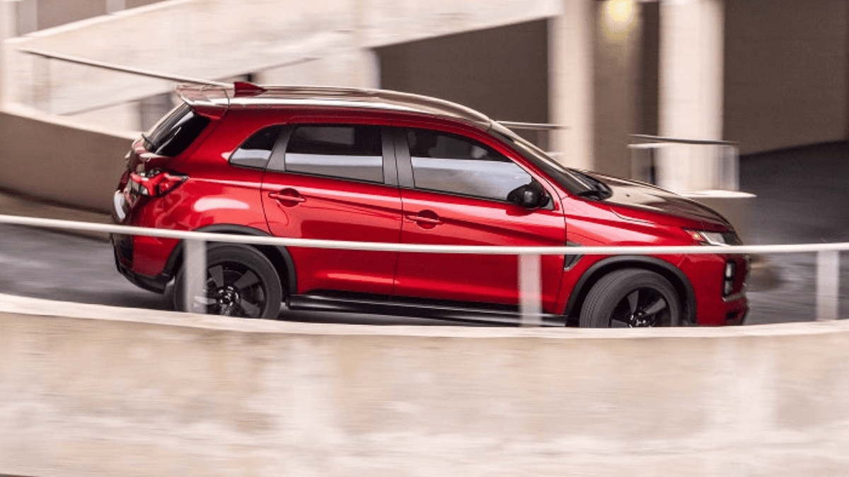 Side profile of the red 2025 Mitsubishi Outlander Sport ascending a spiral ramp near Tampa, FL.