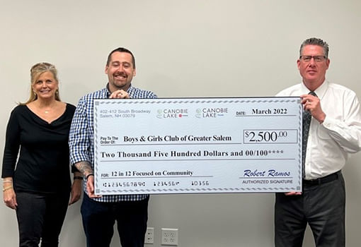 Tres personas sostienen un cheque de $2,500 para el Boys & Girls Club of Greater Salem, apoyando programas y servicios juveniles.