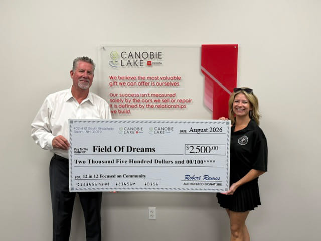 Un cheque de donación gigante de $2,500 siendo entregado a Field Of Dreams.