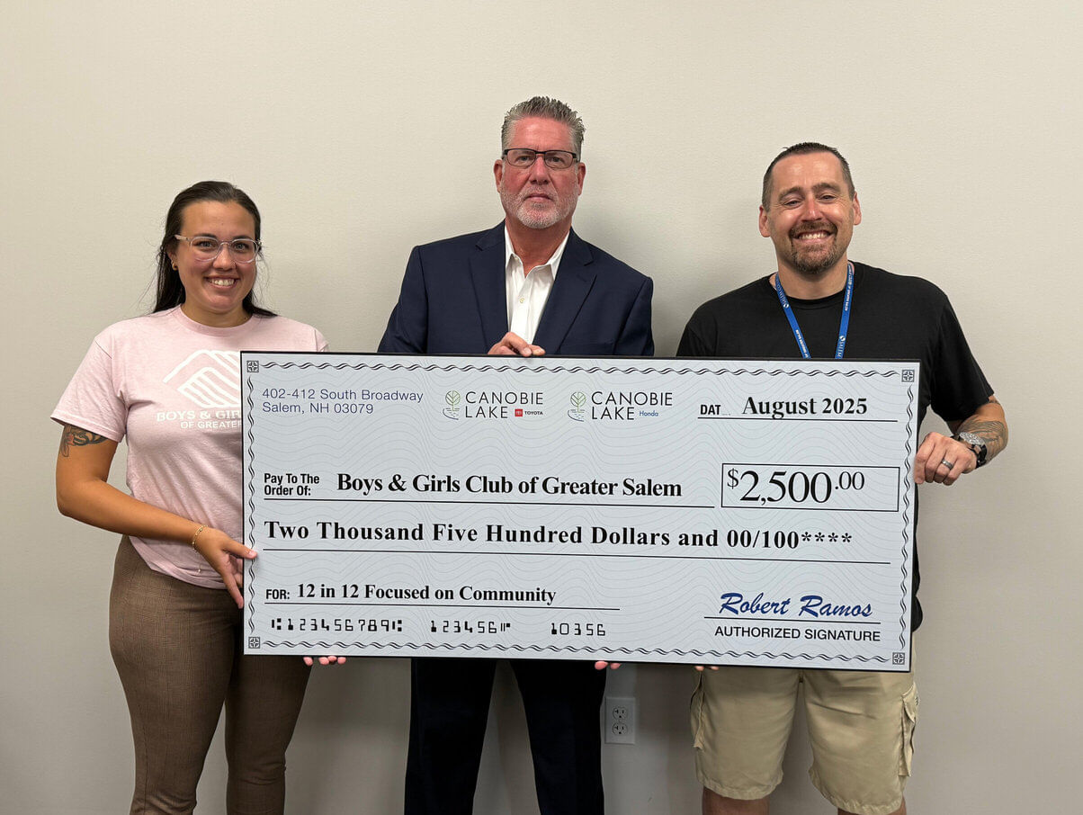 Una mujer y dos hombres sostienen un cheque grande de $2,500 a nombre del Boys & Girls Club of Greater Salem.