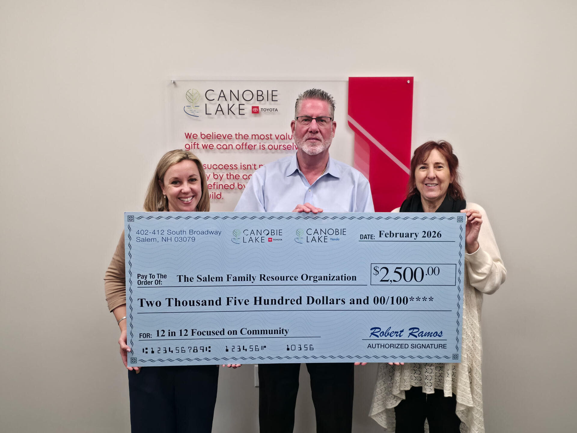 Three people pose with a large ceremonial check for $2,500 from Canobie Lake to the Salem Family Resource Organization.