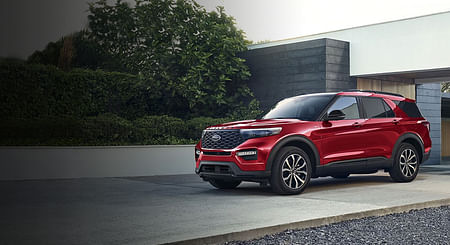 A red Ford Explorer parked in a driveway.