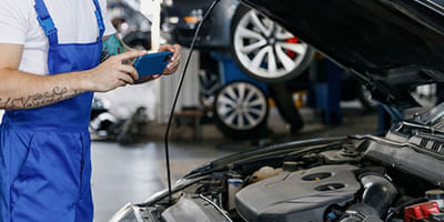 Mechanic checking under the hood of a car