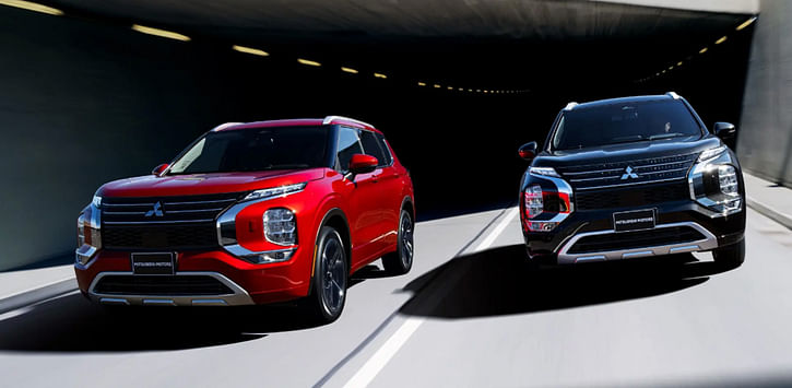 Two mitsubishi SUVs coming out of the tunnel