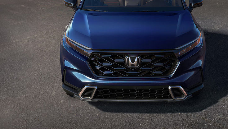 A close-up, high-angle view of the front grille and headlights of a blue Honda CR-V.