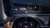 The view from the perspective of a driver driving on the highway at night with the Digital Instrument Cluster and Head-Up Display turned on