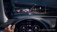 Vista desde la perspectiva de un conductor que circula de noche por la autopista con el cuadro de instrumentos digital y el Head-Up Display encendidos