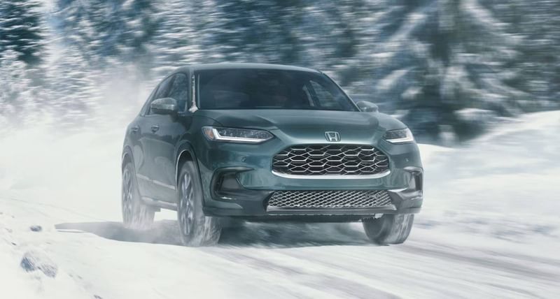 The 2026 HR-V in Nordic Forest Pearl driving in a snow road