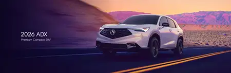2026 ADX Premium Compact SUV on a scenic desert road at sunset. The sleek, modern design is emphasized against purple and orange sky hues.
