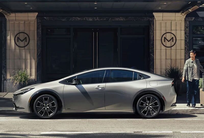 2023 Toyota Prius parked outside with driver walking towards it