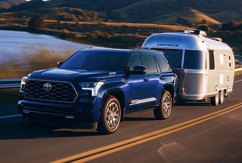 2023 Toyota Sequoia pulling a camper on the road