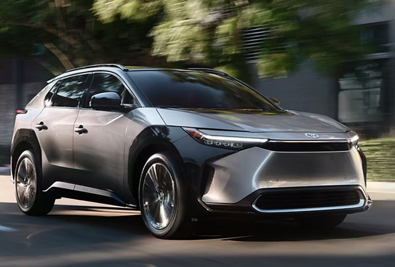 A Toyota SUV driving along a scenic road surrounded by greenery.
