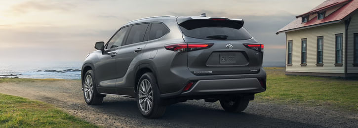 A gray Toyota Highlander Hybrid SUV parked on a road by the ocean.