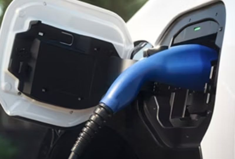 An electric vehicle is connected to a charging station, showcasing the process of recharging its battery.